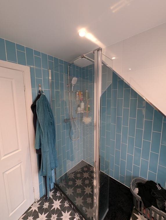 Blue metro-tiled shower with star-pattern floor