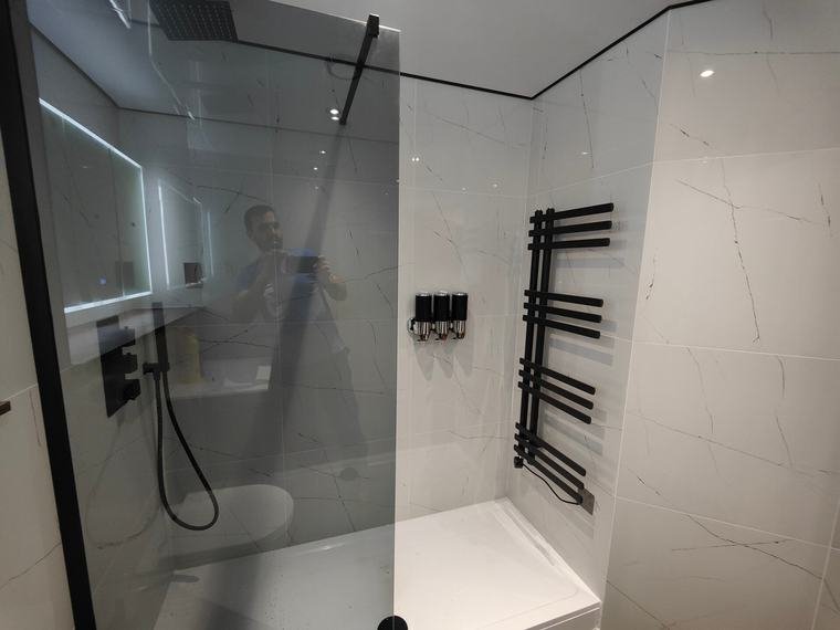 Walk-in shower with black towel rail