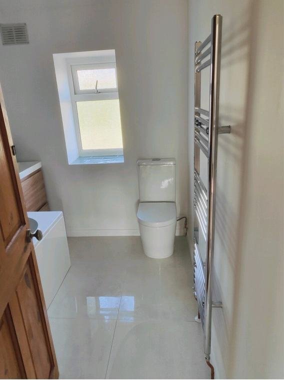 Bright white bathroom with chrome towel rail