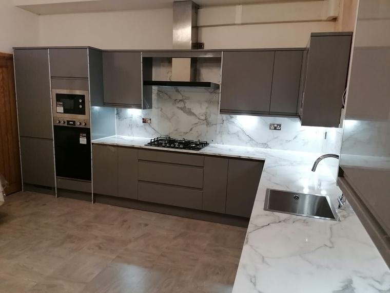 Grey handleless kitchen with marble-effect splashback