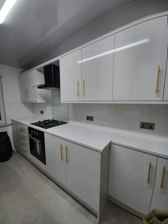 Gloss kitchen with gas hob and gold handles
